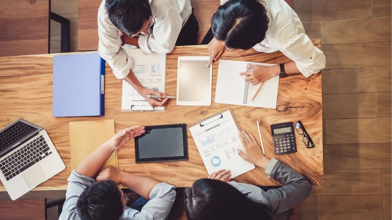 Vue de dessus d’une réunion marketing autour de documents et tablettes